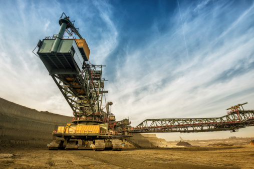 One side of huge mining drill machine photographed from a ground with wide angle lens. Dramatic and colorful sky in background.You can check my other industrial photos...