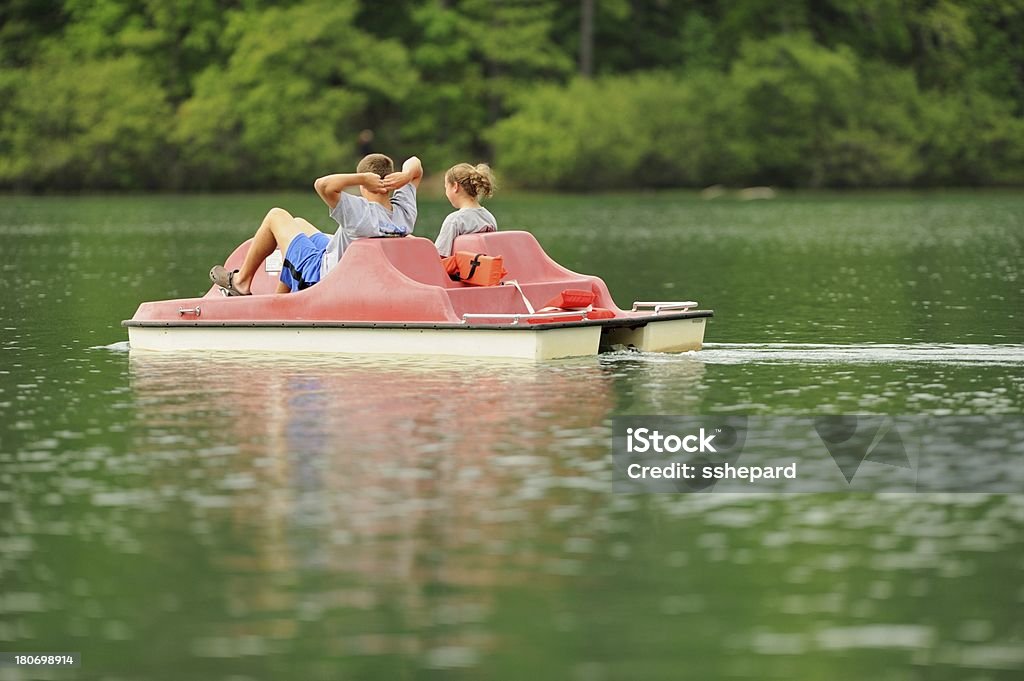 Los niños disfrutan del apacible lago bote de pedales - Foto de stock de Adolescente libre de derechos
