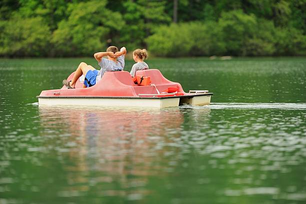 Kids enjoying pedal boat on calm lake