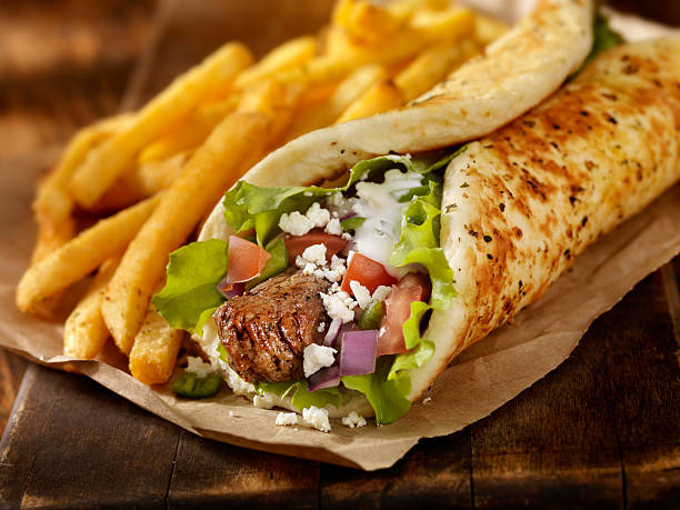 Beef Souvlaki Wrap "Beef Souvlaki Pita Wrap with Lettuce, Tomatoes, Red Onions, Feta Cheese, Tzatziki Sauce and a Side of french Fries -Photographed on Hasselblad H3D-39mb Camera" pita bread stock pictures, royalty-free photos & images