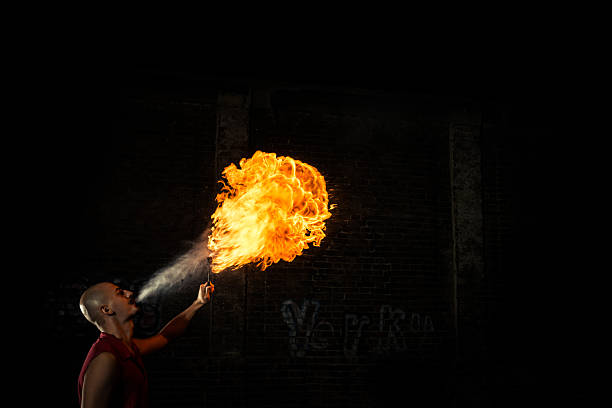 istock Street Performer Fire Breather Blowing on Torch 180699212