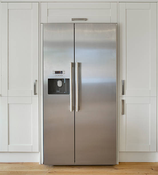 modern American fridge freezer "a modern American fridge freezer set into a bank of cream coloured cupboards in a farmhouse-style kitchen. Made from brushed stainless steel, this is a high quality unit with ice cube dispenser.Looking for a Kitchen, Dining Room or dining related image Then please see my other images by clicking on the Lightbox link below..." stainless steel stock pictures, royalty-free photos & images