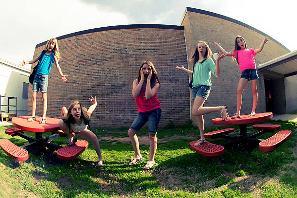 Girls playing on a slide at school.