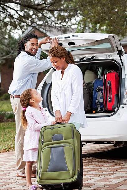 Family loading luggage into car