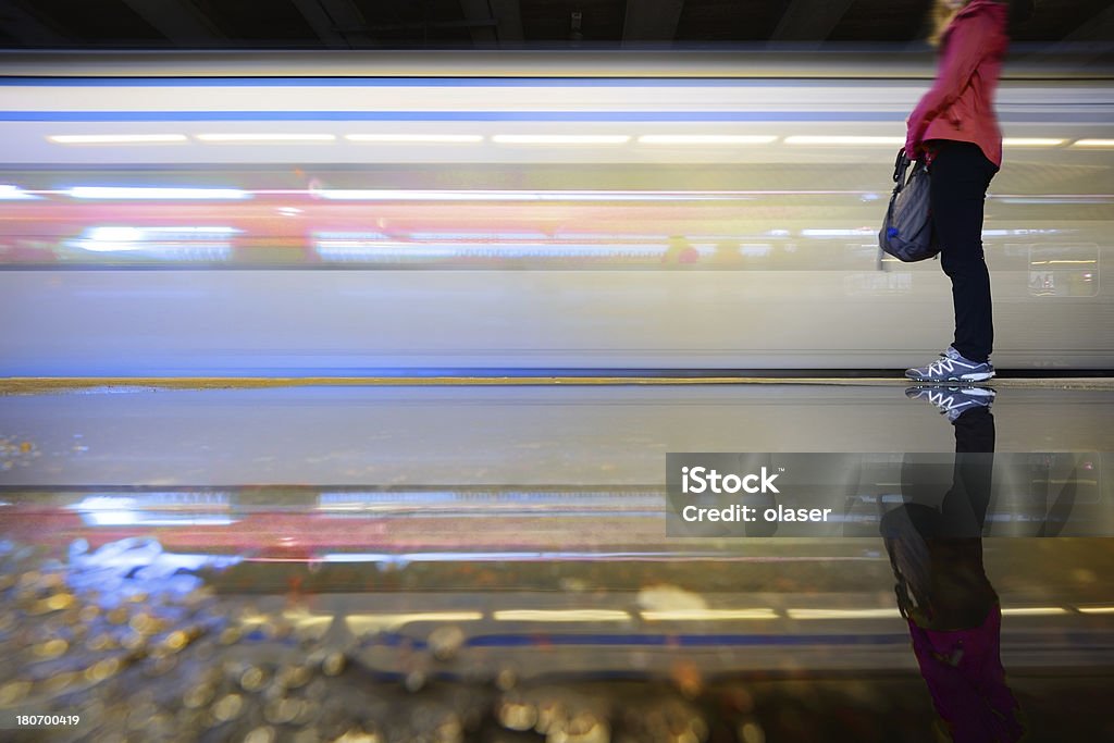Traveller and train reflected in water puddle Passenger waiting for train to stop Rain Stock Photo Traveller and train reflected in water puddle Passenger waiting for train to stop Rain Stock Photo