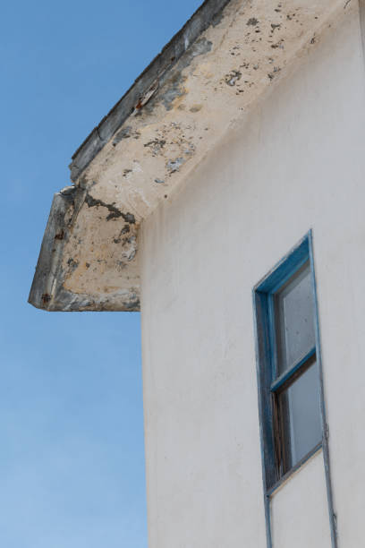 istock Broken concrete hanging off apartment roof 1807004713