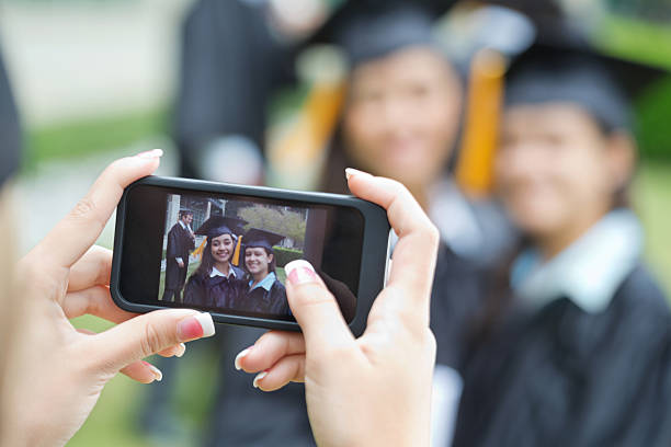 istock Close up of smart phone taking photo with graduates 180700564