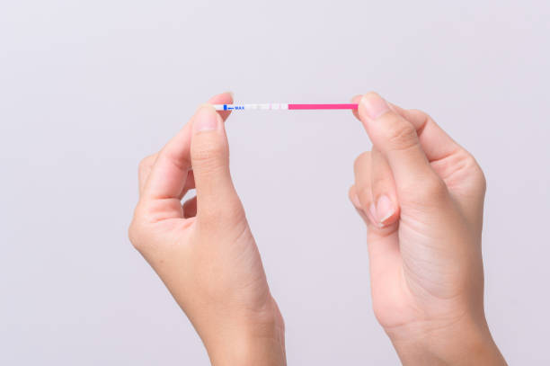 istock Close up woman using Ovalation (LH) test  or (HCG Pregnancy test) on white background 1807013373
