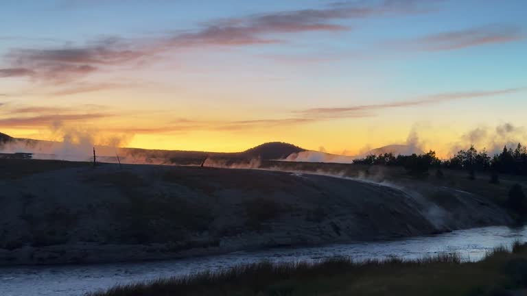 Grand Prismatic Spring dusk sunset mist steam landscape West Yellowstone National Park Old Faithful Grand loop geysers scenic Wyoming Idaho thermal colorful yellow midday cinematic slowly pan left