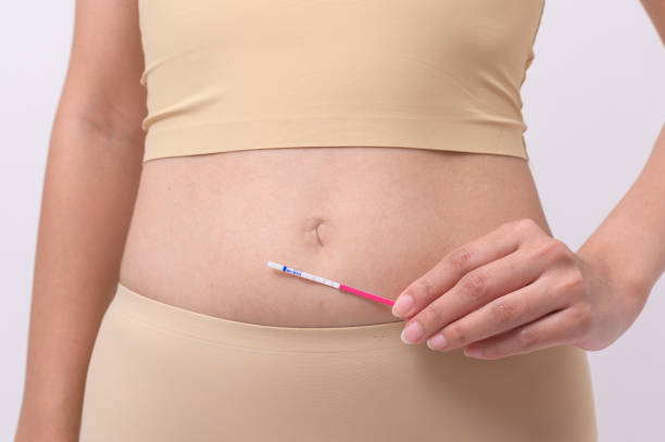 istock Close up woman using Ovalation (LH) test  or (HCG Pregnancy test) on white background 1807013934
