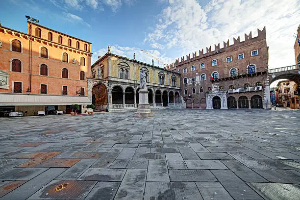 Wide angle view of the central Piazza die Signori with poet Dante Alighieri statue at sunrise.