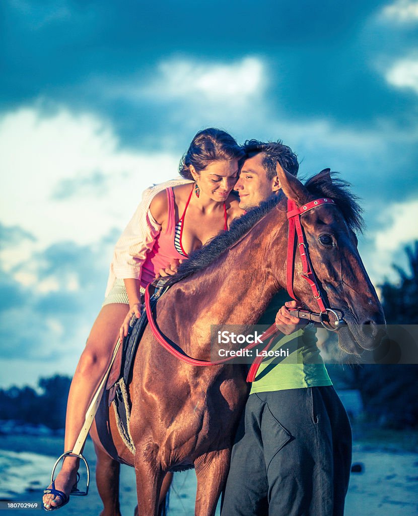 Couple riding horses at sunset Vacation Lifestyles. Couple Horseback Riding at Sunset Horse Stock Photo