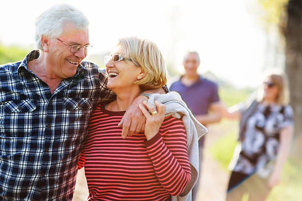 istock Two senior couples enjoy outdoor walk on sunny day 180703700