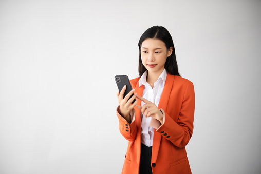 Portrait photo of young beautiful Asian woman feeling happy and holding smart phone, tablet and laptop with black empty screen on white background can use for advertising or product presenting concept.