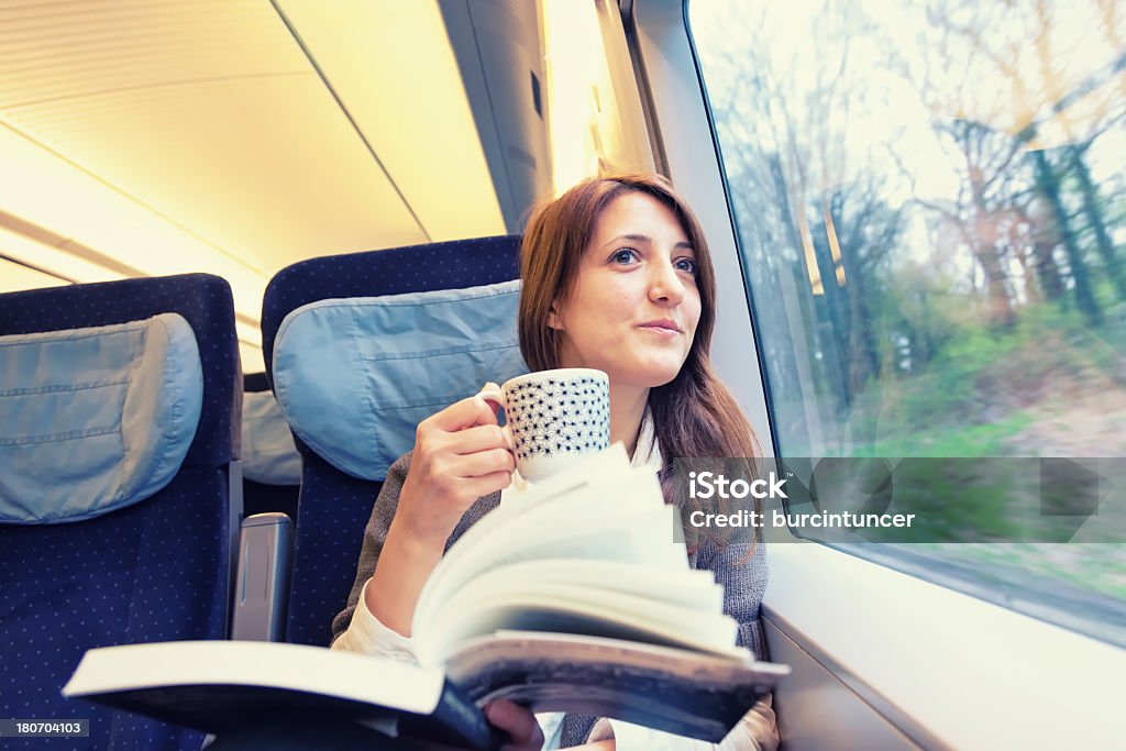 Junge Frau liest Buch und trinkt Kaffee am Bahnhof - Lizenzfrei Eisenbahn Stock-Foto