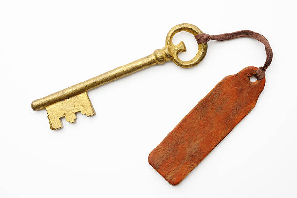 istock Antique skeleton key with old leather tag on white background 180704267