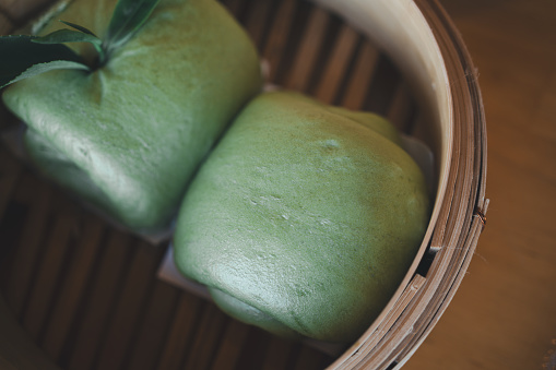 A bamboo tray with Matcha salapao inside.