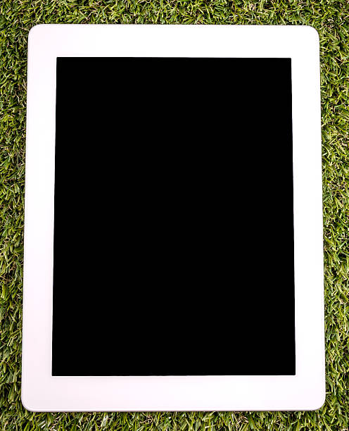 modern white tablette pc sur de l'herbe - liquidcrystal photos et images de collection