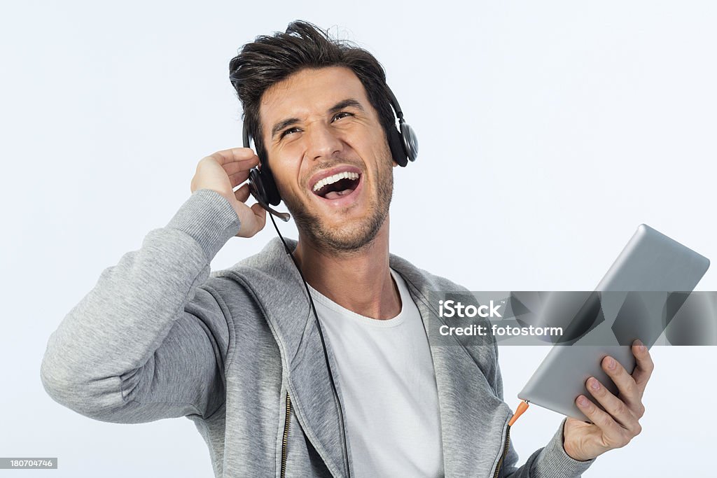 Молодой человек, слушать музыку на цифровой планшет - Стоковые фото 20-29 лет роялти-фри