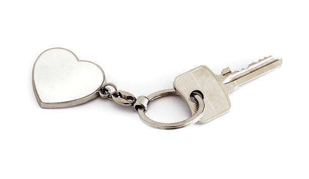 istock A silver key is attached to a white heart key chain. 180704819
