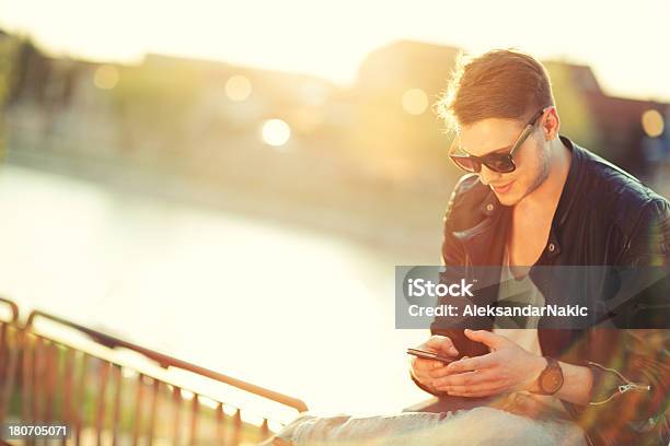 Junger Mann Verwenden Eine Smartphone Im Freien Stockfoto und mehr Bilder von Am Telefon - Am Telefon, Blendenfleck, Cool und Lässig