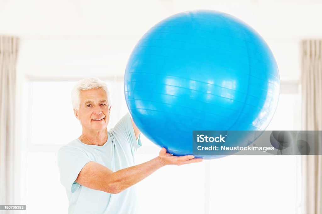 Senior hombre con pelota de ejercicio ejercicio - Foto de stock de 60-69 años libre de derechos