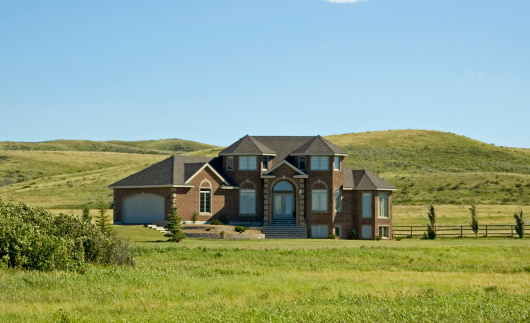 A large modern house located out in the vast praire grasslands of Saskatchewan