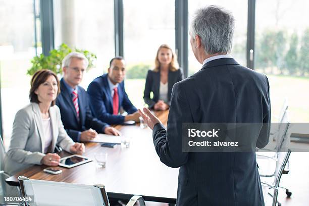 Business Man Giving A Presentation Stock Photo - Download Image Now - Governing Board, Meeting, Multiracial Group