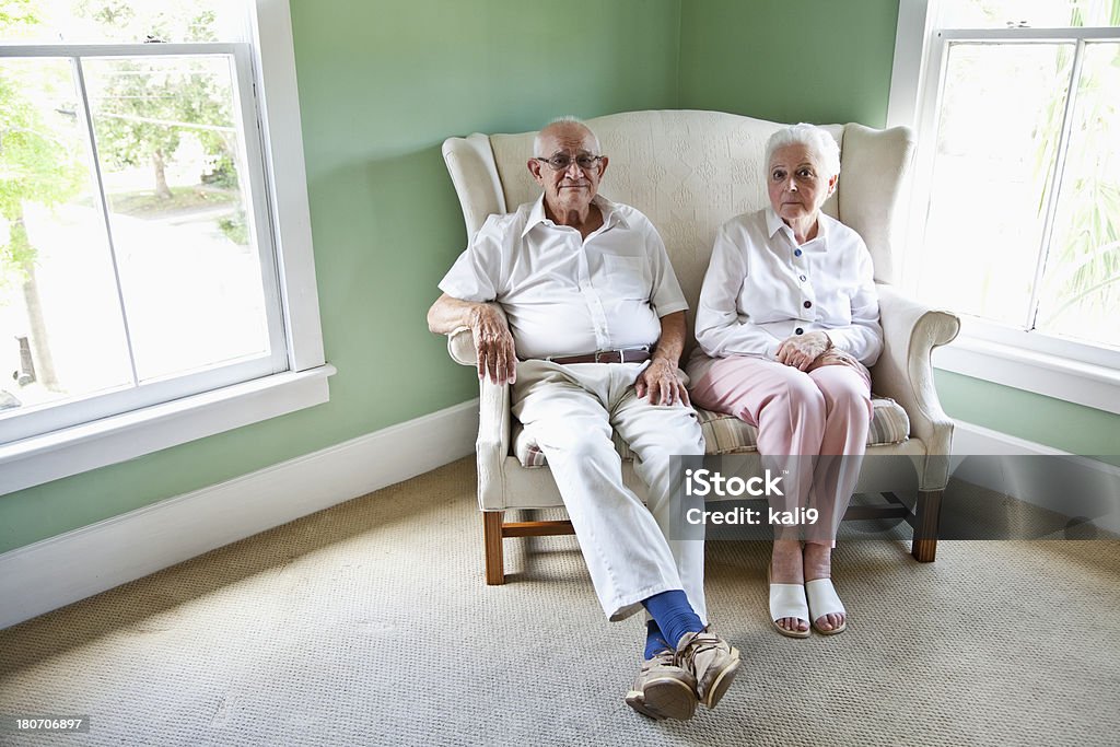 Pareja de ancianos estar juntos en sofá de dos plazas - Foto de stock de 80-89 años libre de derechos