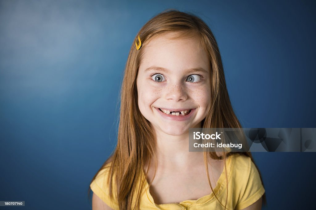 Niña sonriente con el pelo rojo, de cara más desenfadado - Foto de stock de Fondo azul libre de derechos
