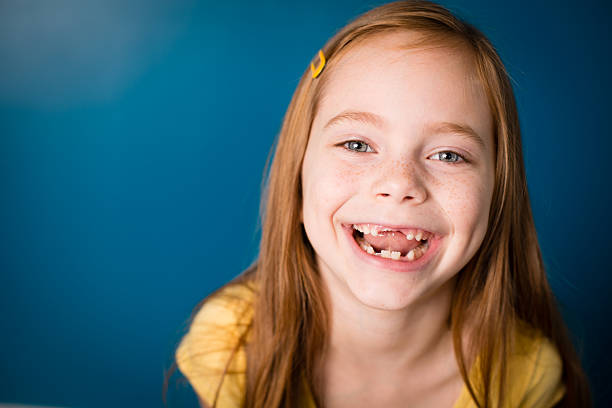 Color Image of Laughing Little Girl With Red Hair "Color image of a laughing,seven year old, red-haired little girl, with blue background." gap toothed photos stock pictures, royalty-free photos & images
