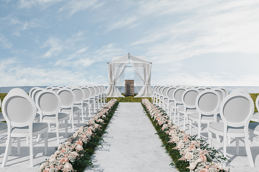 Wedding Ceremony Place On The Beach With White Chairs, Flower Decoration And Wedding Arch
