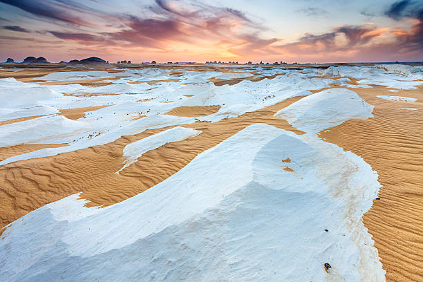 Sunset over The Western Sahara Desert in Africa "Sunset over  The White Desert, part of The Western Sahara Desert in Egypt. The White Desert of Egypt is located 45 km (28 mi) north of the town of Farafra. The desert has a white, cream color and has massive chalk rock formations that have been created as a result of occasional sandstorm in the area." egypt horizon over land sun shadow stock pictures, royalty-free photos & images