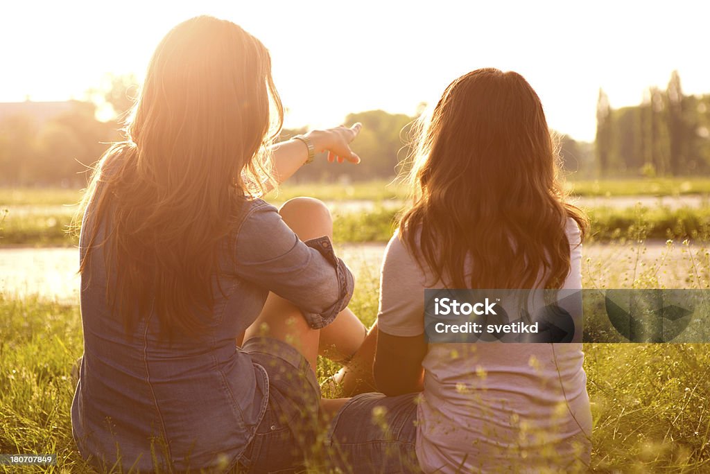 Mujer con su hija disfrutando del sol. - Foto de stock de Vista posterior libre de derechos
