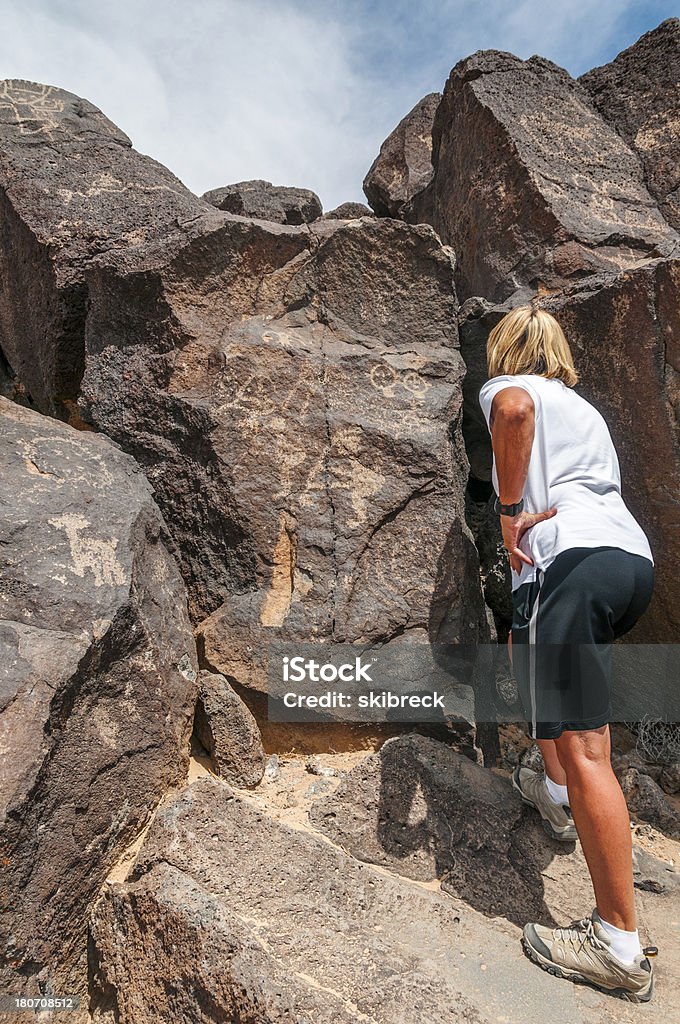 Mulher estudar petróglifos turísticas - Foto de stock de Adulto royalty-free