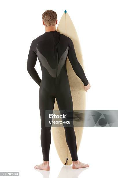 Vista Posterior De Un Hombre De Pie Con Tabla De Surf Foto de stock y más banco de imágenes de 18-19 años