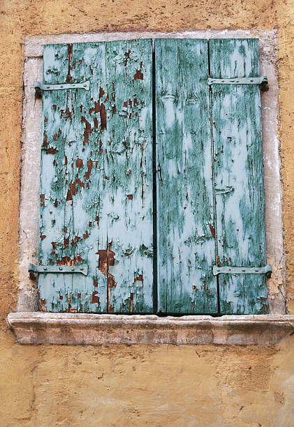 istock Weathered closed window shutters in an old facade 180709327