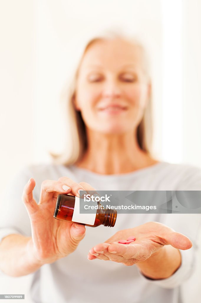 Senior donna prendendo pillole - Foto stock royalty-free di 60-69 anni