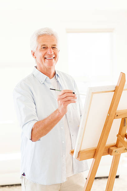 istock Happy Man Painting On Canvas 180710244