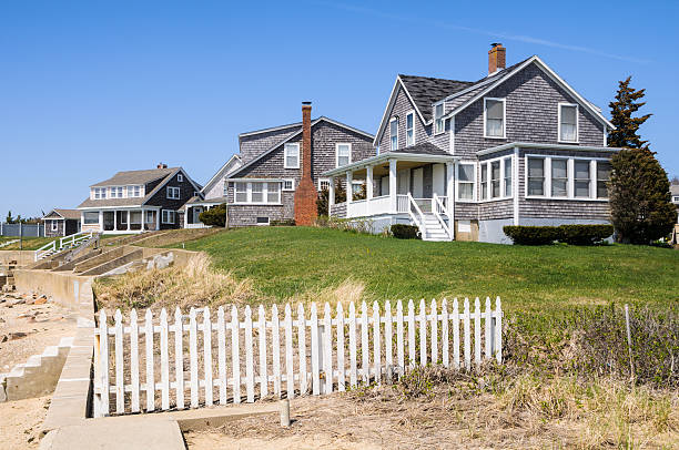 Beach Front Cottages Summer cottages, tucked away behind a concrete surf wall, remain closed up awaiting the upcoming warmer weather on Cape Cod. cape cod stock pictures, royalty-free photos & images