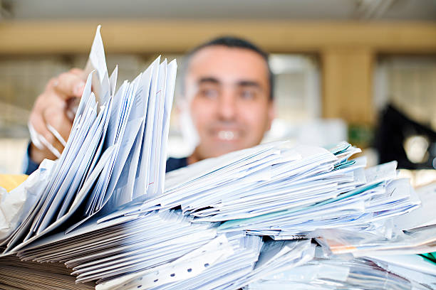 Happy man searching a close-up pile of mail for his letter stock photo