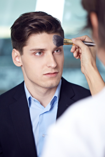 Young man having make-up done