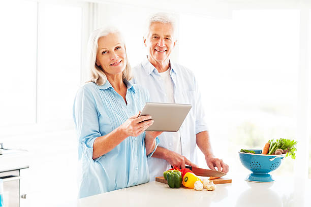 istock Senior Couple With Digital Tablet Cooking In Kitchen 180712008