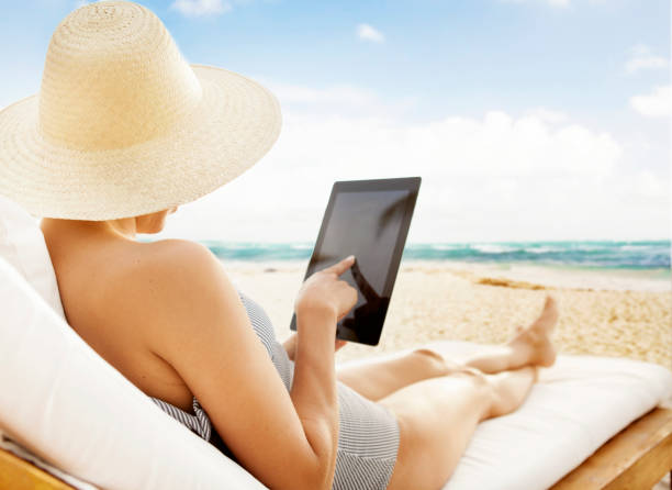 istock Woman with tablet at the beach 180712130