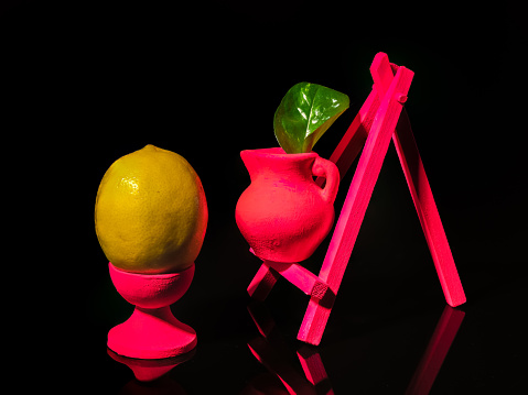 Creative still life with lemon at the easel on a black background