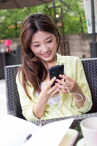 young woman reading message in mobile phone in outdoor