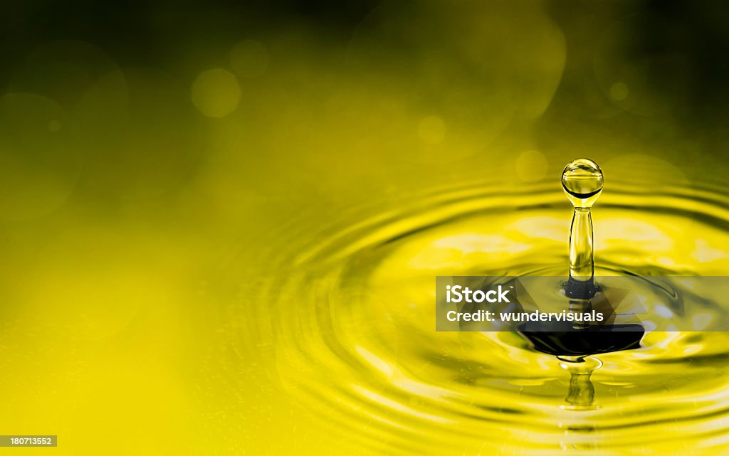 Water drop splashing in lake with ripples Green water background with rain drop falling into lake Backgrounds Stock Photo