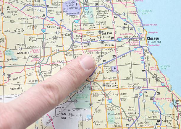 Female hand holding pushpin showing the location of a destination point on a map. Travel destination, pin on the map. Selective focus. Blue pushpin, map on table. High quality photo
