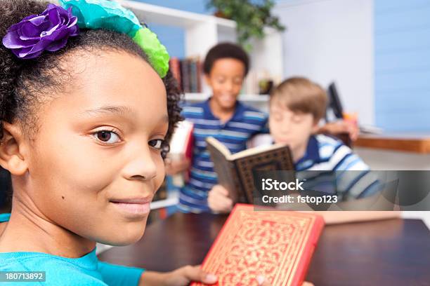 Educação Multi Étnica Alunos Junior Elevado Na Biblioteca Ler A Tabela - Fotografias de stock e mais imagens de 10-11 Anos