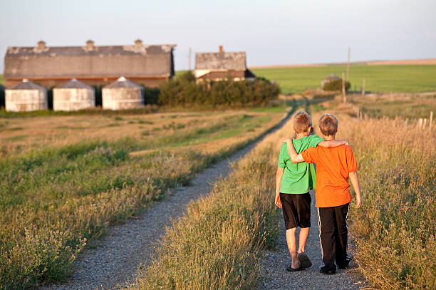 istock Two Boys Walking Down a Country Road 180713924